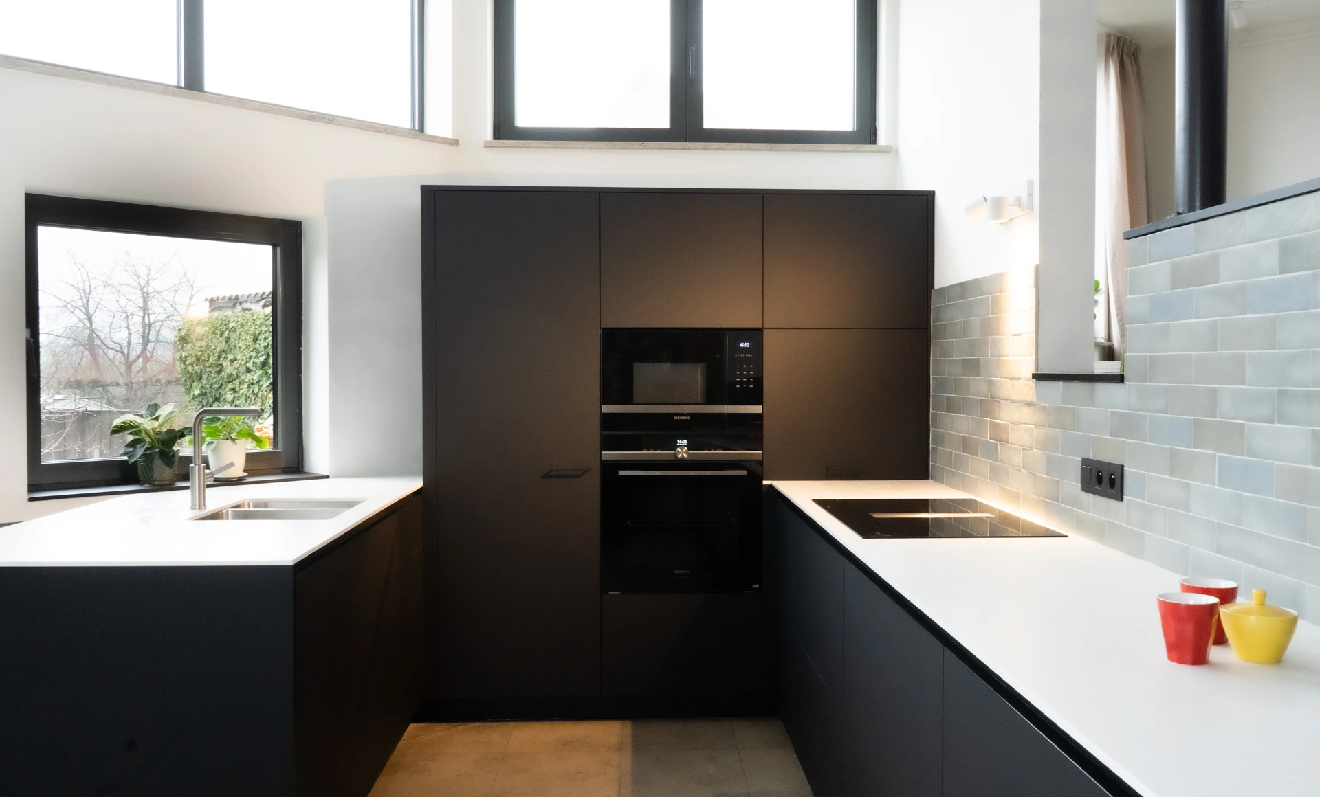 Keuken met donkere maatwerkkasten en een licht werkblad